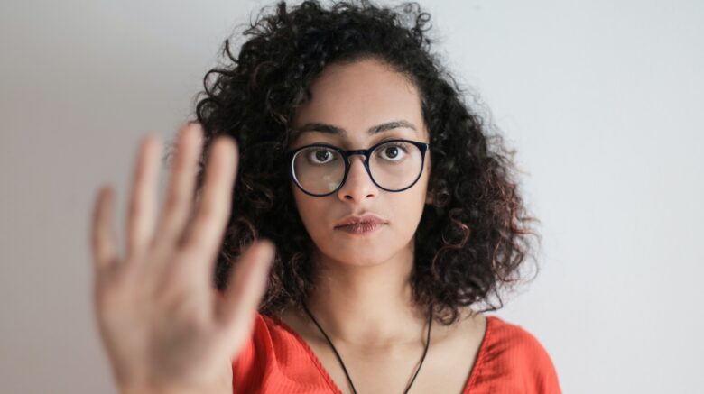 Ragazza che mostra il palmo della mano all'obiettivo per dire no all'odio